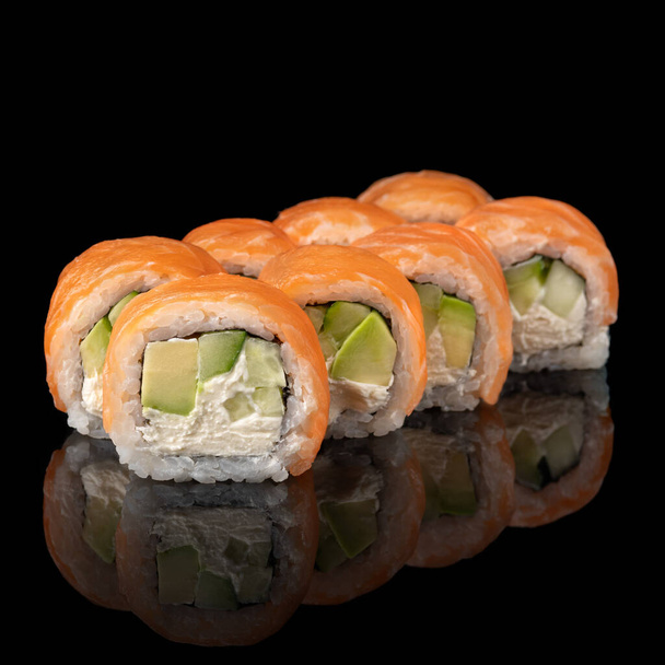 Sushi roll Philadelphia with salmon, prawn, avocado, cream cheese on black background. Sushi menu. Japanese food. - Фото, зображення