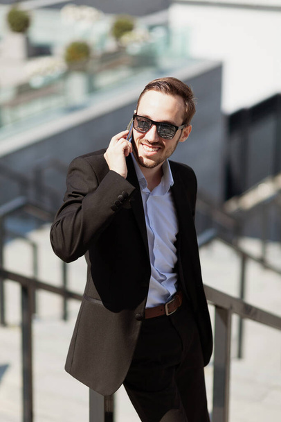 Business man raised his glasses to watch good news on phone, pleasant surprise. - Fotografie, Obrázek