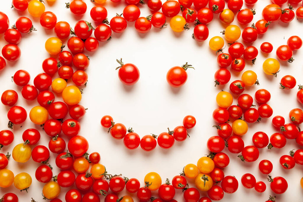Red and yellow cherry tomatoes, fresh bright organic vegetables. Smiling face. - Foto, Bild