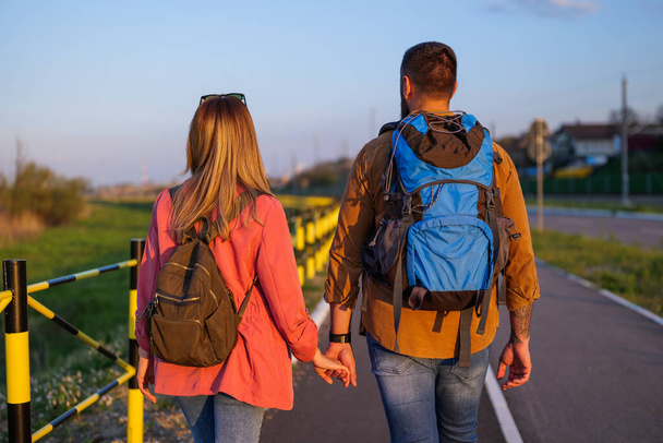 Adult couple is walking together by the road and holding hands. - Photo, Image