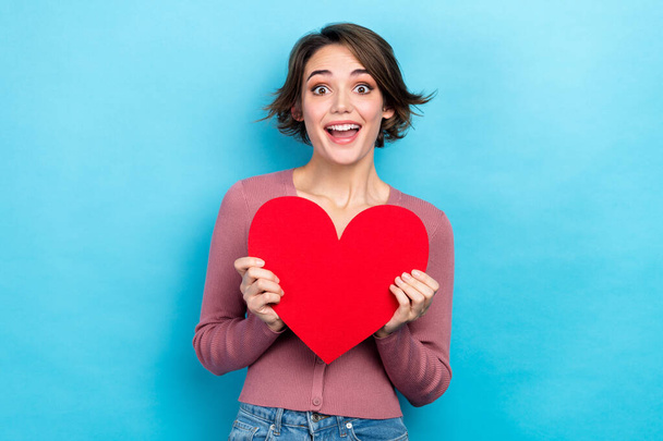 Portrait of lovely positive person hands hold paper heart symbol card isolated on blue color background. - Fotó, kép