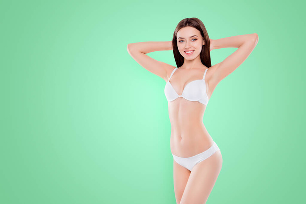 Lifestyle wellbeing cosmetics rejuvenation slimming weight loss concept. Portrait of gorgeous skinny girl with ideal pure groomed sportive body holding hands behind head isolated on white background. - Foto, Imagem