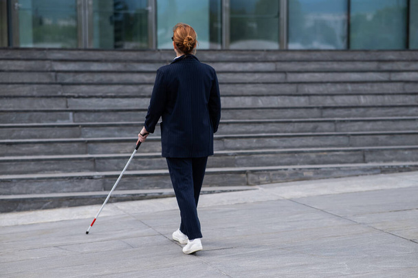 Blind businesswoman walking with tactile cane to business center - Foto, immagini