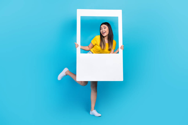 Full size portrait of funky carefree girl hold paper album set card isolated on blue color background. - Foto, Imagen