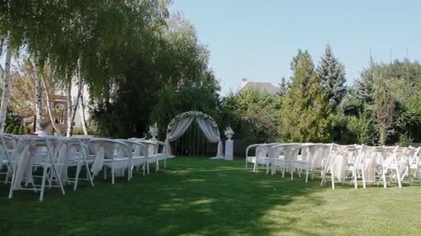 Hochzeitsdekoration mit Bogen und weißen Stühlen - Filmmaterial, Video