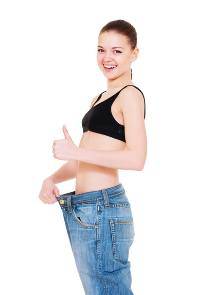 Woman in big jeans showing thumbs up - Foto, Imagen