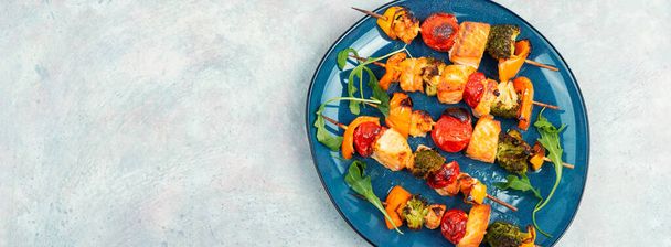 Skewers of fish salmon and vegetables on wooden stick. Seafood kebab. Copy space. Long banner. - Photo, Image