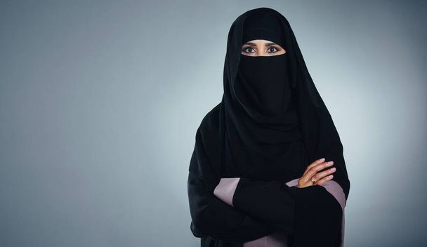 Müslüman olmaktan gurur duyuyorum. Gri bir arka planda genç bir Müslüman iş kadınının stüdyo portresi - Fotoğraf, Görsel