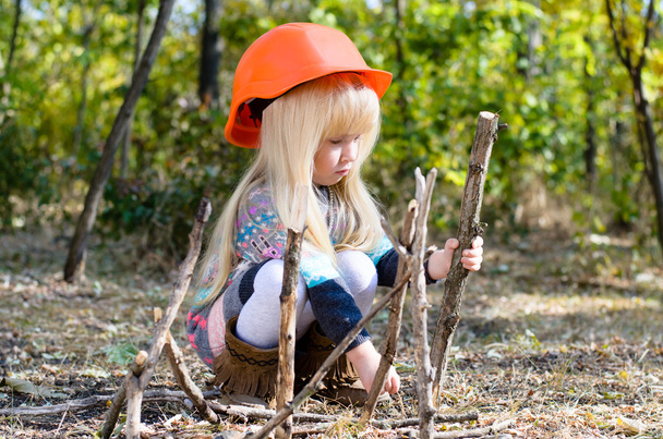 Little Girl with Helmet Playing with Sticks - Photo, Image