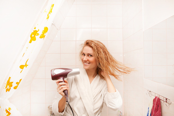 schöne Frau trocknet ihre Haare mit Haartrockner - Foto, Bild