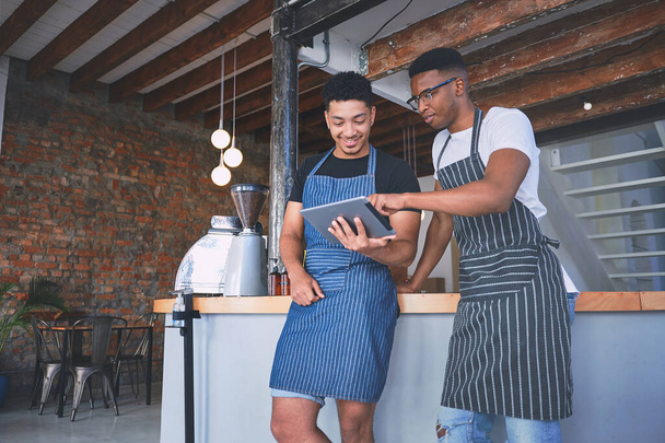 Pětihvězdičková služba v reálném čase a online. dva mladí muži pomocí digitální tablet při práci v kavárně - Fotografie, Obrázek