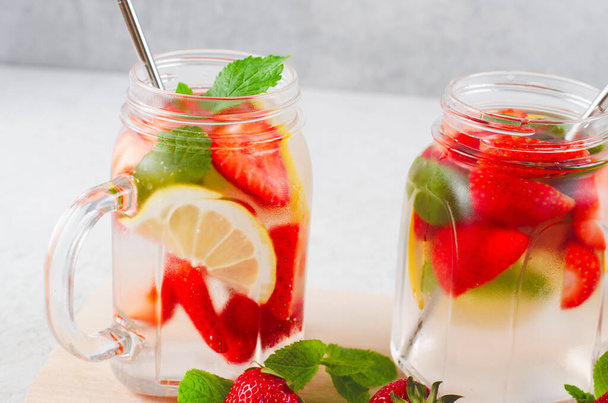 Strawberry Infused Water, Refreshing Cocktail, Lemonade, Detox, Summer Iced Drink with Fresh Strawberry, Lemon and Mint on Bright Background - Photo, Image