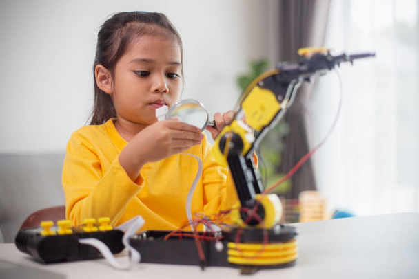 Koncepcja edukacji STEM. Studenci azjatyccy uczą się w domu, kodując broń robotów w STEM, kod komputerowy inżynierii matematyki w robotyce dla koncepcji dzieci. - Zdjęcie, obraz