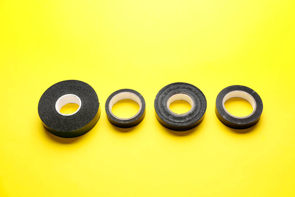 Adhesive tape rolls on yellow background - Foto, afbeelding