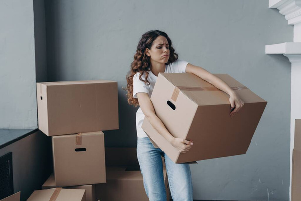 Uitgeputte huurder met zware dozen op verhuisdag. Verontrustende Spaanse meisje verlaten gehuurd appartement - Foto, afbeelding