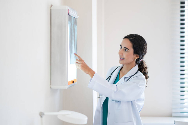 portrait of young medical doctor looking at an x-ray image in the office - Foto, Bild
