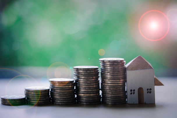 Faház modell ház pénzköteg lépés nő a fa asztalra. Pénztakarékos pénzügyi koncepció. Vállalkozások növekedési beruházásai és pénzügyi - Fotó, kép