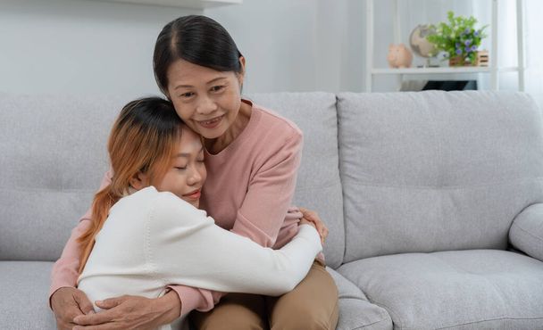 Moederdag, schattig aziatisch tiener meisje knuffelen volwassen middelbare leeftijd moeder. Liefde, kus, zorg, vrolijke glimlach geniet van familie tijd. Vier een speciale gelegenheid, gefeliciteerd, vrolijk kerstfeest. speciaal  - Foto, afbeelding