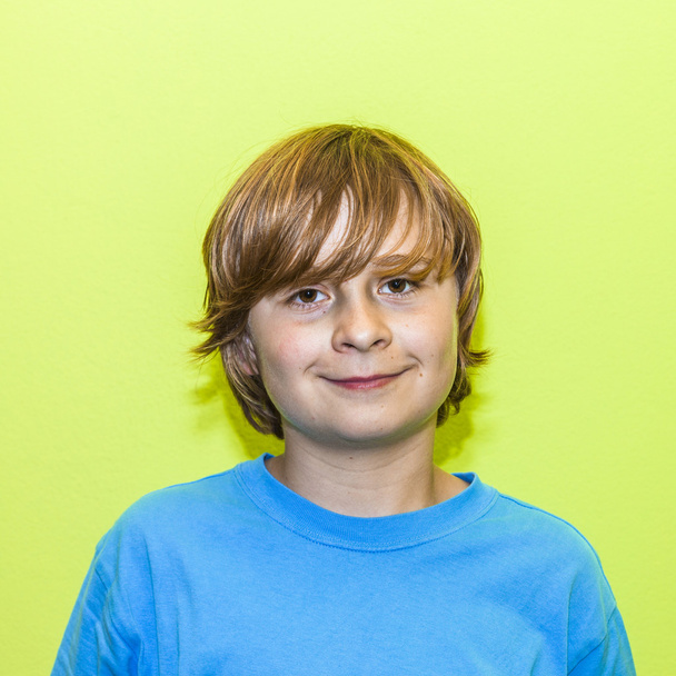 šťastný usmívající se mladý chlapec se žlutou stěnou - Fotografie, Obrázek