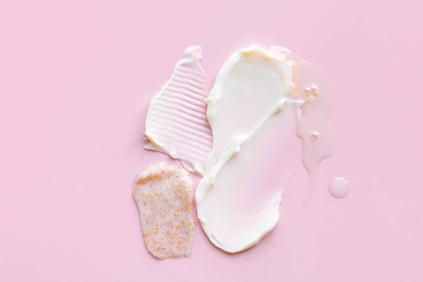 Swatch van witte crème textuur, koffie scrub, olie cosmetica voor gezicht en lichaam op een geïsoleerde licht roze achtergrond. Smear. - Foto, afbeelding