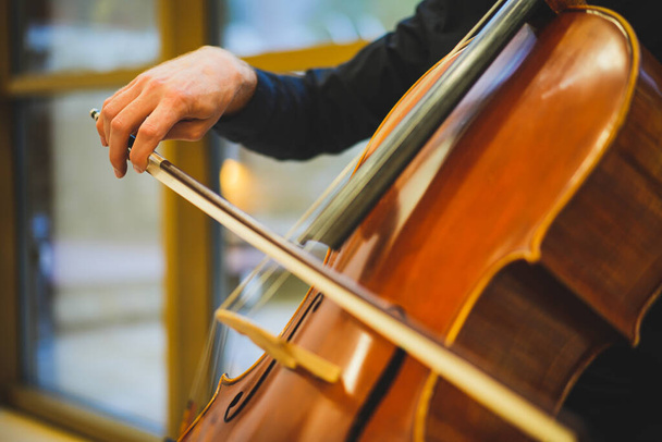 Detail view of an unrecognizable man playing the cello in public. - Foto, Imagen