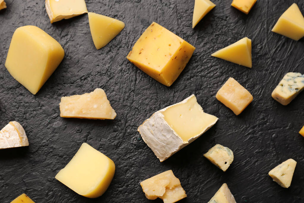 Trozos de sabroso queso sobre fondo oscuro - Foto, imagen