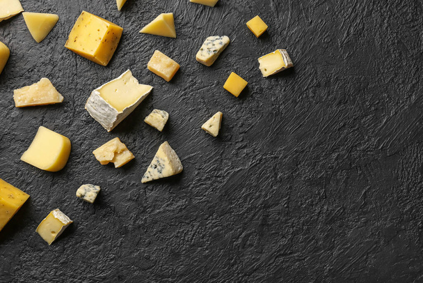 Morceaux de fromage savoureux sur fond sombre - Photo, image