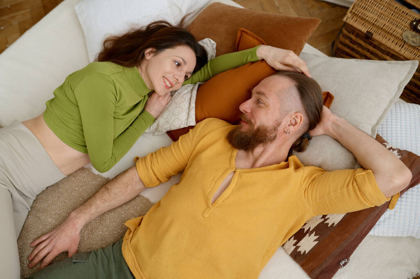Happy fit desportivo sorridente homem e mulher descansar após o treinamento de ioga, enquanto deitado na cama com almofadas, vista aérea. .. Peça, amor e relaxe conceito - Foto, Imagem