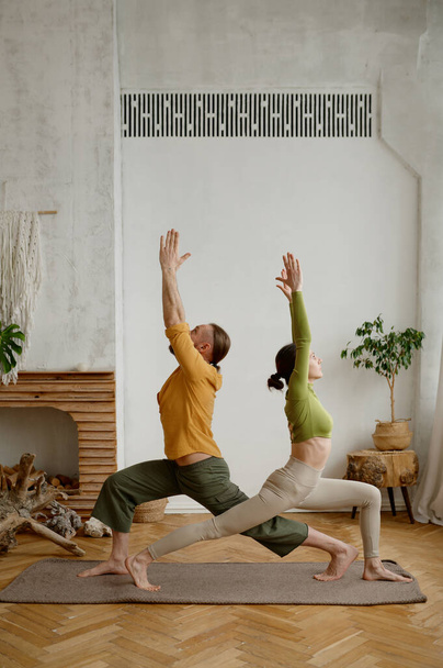 Nuori mies ja nainen pari harjoitellaan jooga yhdessä seisoo kolmio aiheuttaa. Terveet elämäntavat ja urheilu päivittäinen rutiini käsite - Valokuva, kuva