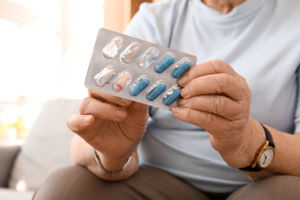 Senior woman with pills at home, closeup - Foto, imagen