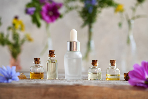 Пять бутылок ароматерапии эфирных масел с ладан смолы, трав и цветов - Фото, изображение