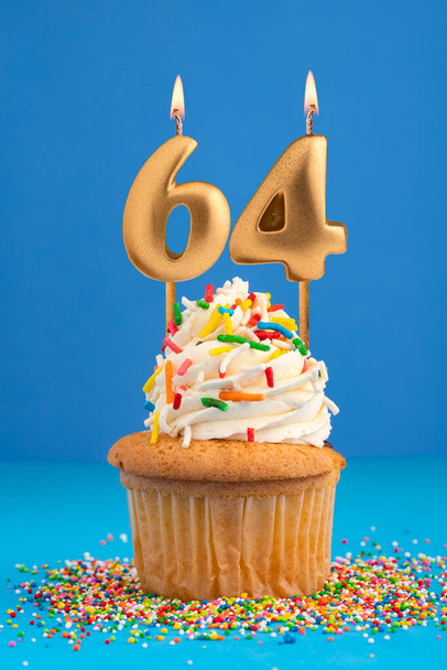 Birthday cake with candle number 64 - Blue background - Foto, imagen