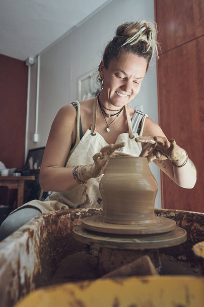 Hay mucho que amar en la vida de la cerámica. una joven que trabaja con arcilla en un estudio de cerámica - Foto, Imagen