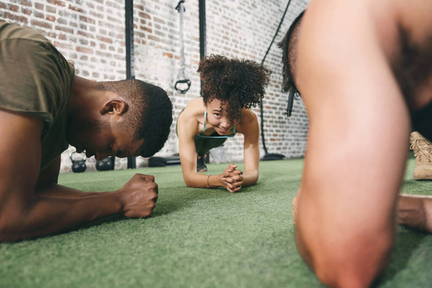 Αφιερώστε τον εαυτό σας να γίνει το καλύτερό σας. fitness group planking ενώ ασκείστε στο γυμναστήριο - Φωτογραφία, εικόνα