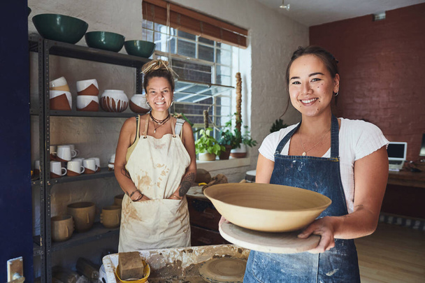Whats made by you is much more appreciated. two young women making a bowl in a pottery studio - Фото, изображение