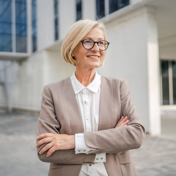 Portrait of one caucasian blonde mature businesswoman stand outdoor - Foto, Imagen