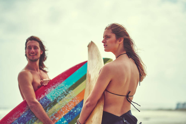 Никогда не поворачивайся спиной к хорошей волне. молодая пара, проводящая день на серфинге - Фото, изображение