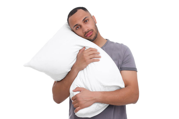 Tired man with pillow on white background. Insomnia problem - Fotoğraf, Görsel