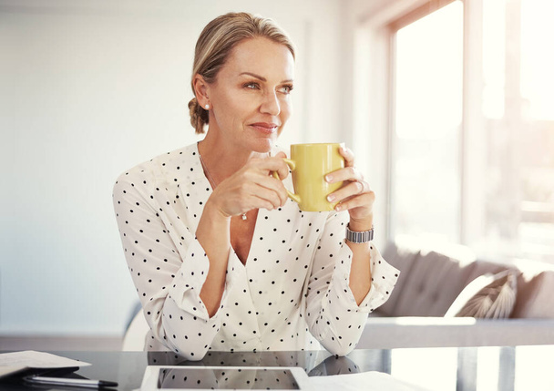 Koffie thuis dan werken vanuit huis. een volwassen zakenvrouw werken vanuit haar kantoor - Foto, afbeelding