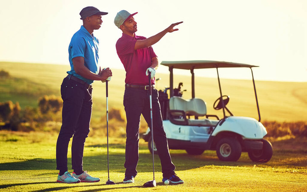 Todos jugamos golf con extraños pero nos vamos como amigos. dos amigos jugando una ronda de golf en un campo de golf - Foto, imagen