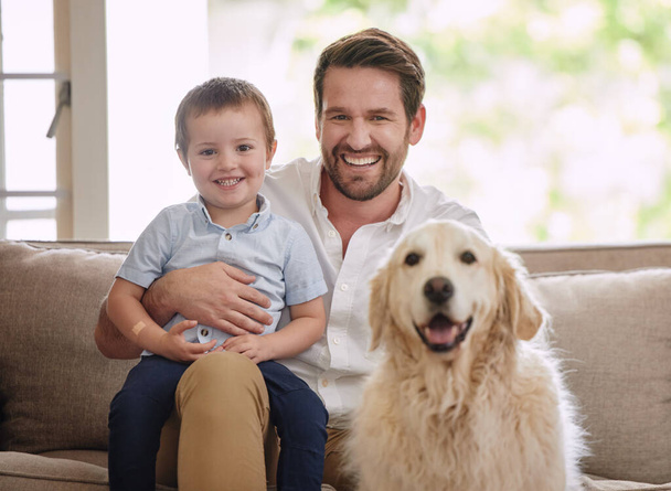Vader, huisportret en hond met kind in de woonkamer voor liefde, geluk en quality time. Dier, huisdier en vader met jong kind, golden retriever en glimlach om te ontspannen op een bank in een lounge samen. - Foto, afbeelding