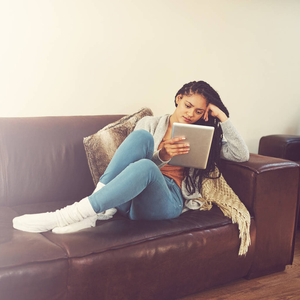 Jsem do téhle série blázen. mladá žena pomocí svého tabletu při relaxaci doma - Fotografie, Obrázek