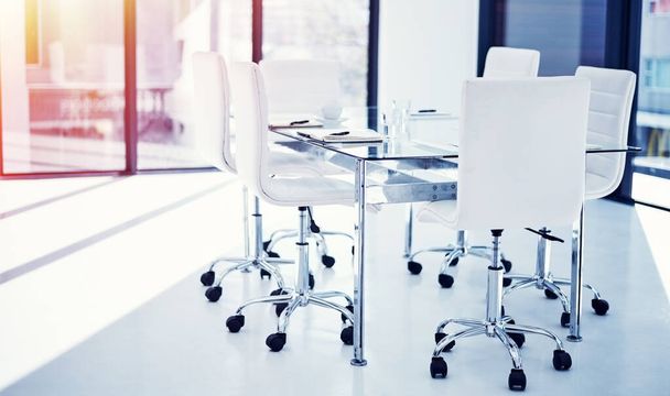 Workers should be able to take pride in their workplace. an empty boardroom furnished with a table and chairs - Фото, зображення