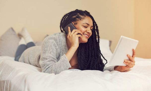 Llamando a mi opción de entrega favorita. una mujer joven hablando por teléfono mientras mira algo en su tableta - Foto, imagen