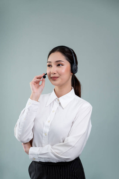 Opérateur attrayant centre d'appels asiatique féminin avec sourire heureux visage annonce possibilité d'emploi sur l'espace vide, portant un costume formel et casque sur fond isolé personnalisable. Enthousiaste - Photo, image