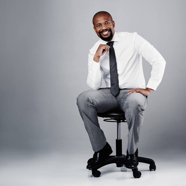 As a leader, youve got to be a forward-thinker. Studio portrait of a corporate businessman sitting on a chair against a grey background - Foto, Imagem
