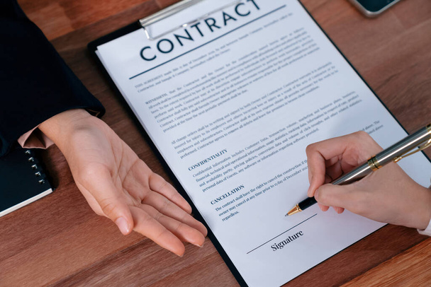 Closeup hand signing contract document with pen, sealing business deal with signature. Businesspeople finalizing business agreement by writing down signature on contract paper. Enthusiastic - Foto, immagini