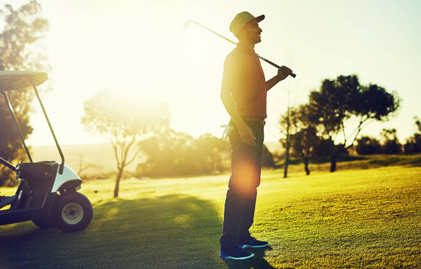 Nothing feels as good as being on the greens. a young man playing golf - Foto, imagen