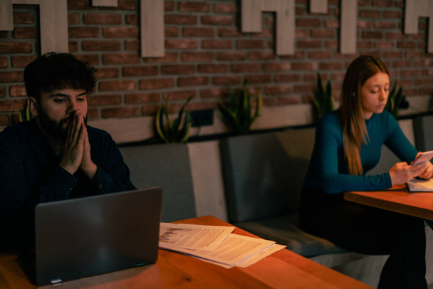 Due giovani studenti seduti al caffè che lavorano e si fanno gli affari propri - Foto, immagini