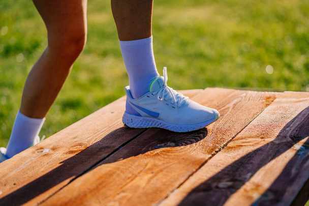 Een foto van de benen van sportieve meisjes in sportschoenen en sokken - Foto, afbeelding